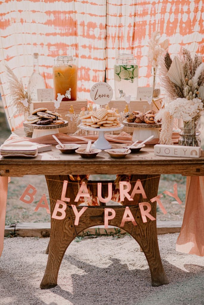 Un bar à gourmandise entouré d'une décoration rosée est idéale pour une baby shower fille