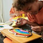 Creative kid making rainbow out of